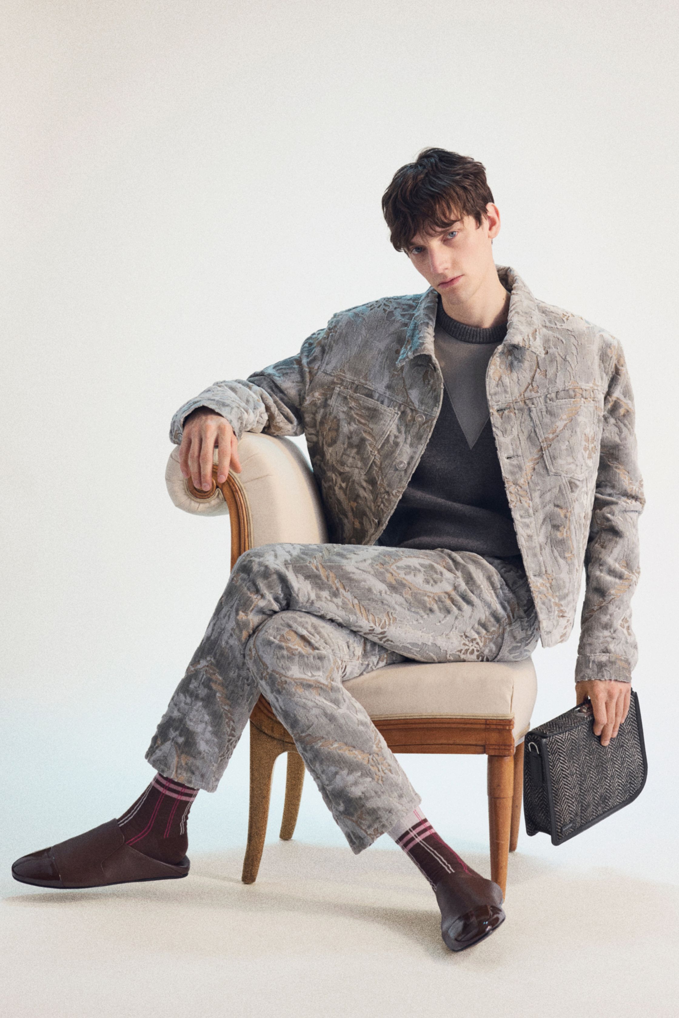 Lanvin 2026秋冬男装以“温和力量”为主线，将法式优雅重新校准到当代男装语境。宽肩大衣、绗缝夹克与精致针织并置，构建出介于正式与休闲之间的流动结构；橄榄绿、灰褐与低饱和蓝形成理性而内敛的色阶。造型在剪裁上克制而精准，强调身体与衣物的自然关系，呈现一种安静却持久的高级感，映射当下男性气质的松弛与自省-顽石频道趋势研究